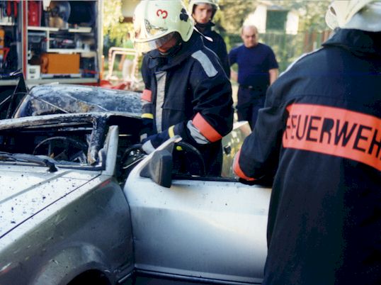 PKW wird von Kameraden der Feuerwehr mit der Scheere zerschnitten